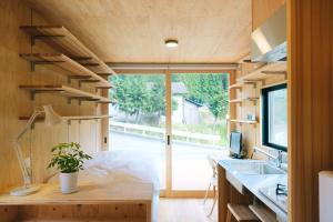 ein kleines Haus mit einem großen Fenster und einem Schreibtisch in der Unterkunft 安全第一 客室　コンテナハウス in Nishiawakura