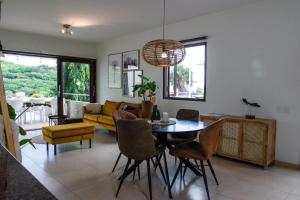 een woonkamer met een tafel en stoelen en een bank bij Blue Bay Resort luxury apartment Green View in Dorp Sint Michiel