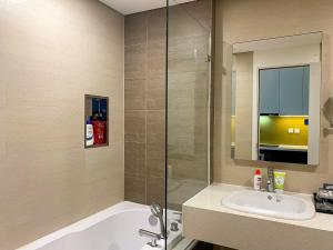y baño con bañera, lavabo y espejo. en A25 Hotel - 18 Nguyễn Hy Quang, en Hanói