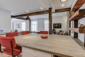 a kitchen and living room with a large table and red chairs at FUNCTIONAL AND COZY APARTMENT - CITE LIMOILOU in Quebec City