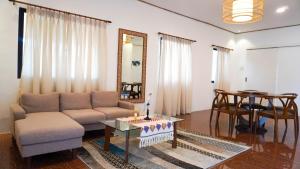 ein Wohnzimmer mit einem Sofa und einem Tisch in der Unterkunft UNWND BOUTIQUE HOTEL CALATAGAN in Batangas City