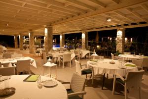 a restaurant with white tables and chairs and lights at Aktaion Resort in Gythio