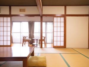 uma sala de estar com uma mesa e algumas janelas em Harukaze no Yado em Iwaki