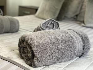 a gray towel sitting on top of a bed at Modern Spacious 1 Bed Apartment with Free Parking in Trendy Inner London Suburb 15 mins walk to Victoria Line Underground then 20 mins to Oxford Street "West End of London" or 10 mins walk to Overground and 10 mins to London Liverpool St "City of London" in London