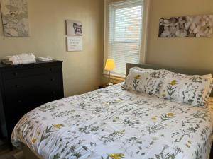 - une chambre avec un lit avec une couette à fleurs et une fenêtre dans l'établissement Hudson #1 Private Two Bed near Xavier & Downtown, à Cincinnati