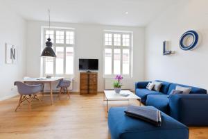 ein Wohnzimmer mit einem blauen Sofa und einem Tisch in der Unterkunft Soltausche Buchdruckerei - Whg 01 in Norderney
