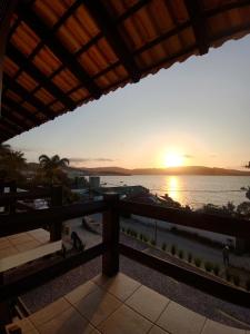a sunset view from the balcony of a resort at Pousada Caminho do Mar in Bombinhas