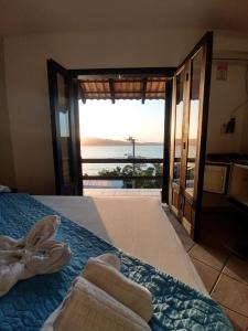 1 dormitorio con 1 cama y vistas al océano en Pousada Caminho do Mar, en Bombinhas