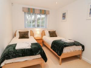 a bedroom with two beds and a window at A Stone's Throw in Torpoint