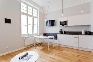 a kitchen with white cabinets and a table in a room at Soltausche Buchdruckerei - Whg 02 in Norderney