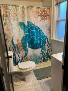a bathroom with a shower curtain and a toilet at Hunter #1, Private One Bed near Xavier & Downtown in Bellevue