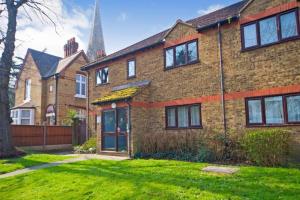 a brick house with a tower in the background at Modern Spacious 1 Bed Apartment with Free Parking in Trendy Inner London Suburb 15 mins walk to Victoria Line Underground then 20 mins to Oxford Street "West End of London" or 10 mins walk to Overground and 10 mins to London Liverpool St "City of London" in London