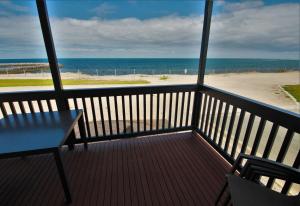 a balcony with a table and a view of the beach at Edithburgh Caravan Park in Edithburgh