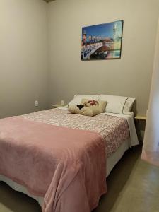 a bedroom with a bed with a pink blanket at D'Santos Hospedaria. Aconchego perto de Tiradentes in Coroas