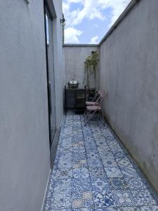 a small courtyard with a chair on a tiled floor at D'Santos Hospedaria. Aconchego perto de Tiradentes in Coroas