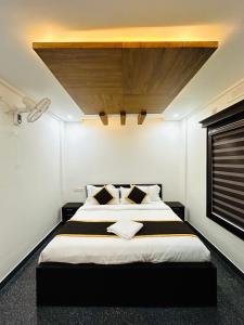a bedroom with a large bed with a wooden ceiling at BEVERLY SUITES in Wayanad