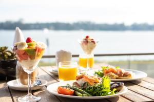 una mesa con platos de comida y vasos de zumo en Ana Mandara Luxury Retreat en Port Macquarie