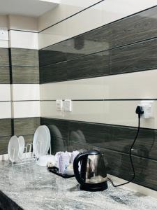 a kitchen with two toilets and a tea kettle on a counter at BEVERLY SUITES in Wayanad