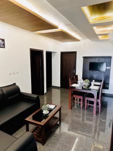 a living room with a couch and a table at BEVERLY SUITES in Wayanad