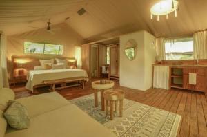 a large bedroom with a bed and a couch at Zunya in Santa Teresa Beach