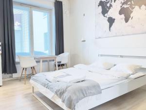 赫爾辛基的住宿－Authentic Central Apartment Helsinki，白色卧室配有一张挂着世界地图的床