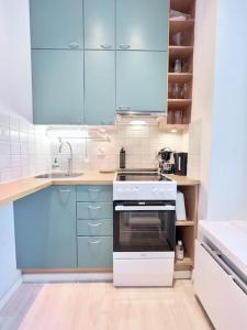 赫爾辛基的住宿－Authentic Central Apartment Helsinki，厨房配有蓝色橱柜和白色烤箱