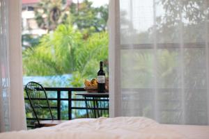 暹粒的住宿－Siem Reap Homesteading，一张桌子,上面放着一瓶葡萄酒和一盘食物