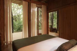 a bedroom with a bed and a large window at Zunya in Santa Teresa Beach