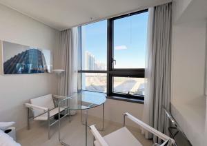 a room with a glass table and a window at UH FLAT THE SONGDO in Incheon