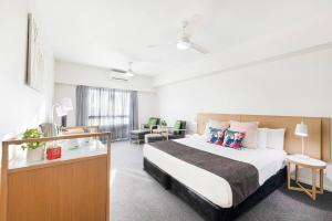 um quarto de hotel com uma cama e uma escrivaninha em 'A Perfect Match' Resort-style Living in Darwin CBD em Darwin