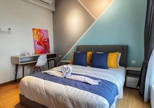 a bedroom with a large bed with blue and yellow pillows at Comfy Imperium Residence Kuantan Studio Seaview in Kuantan