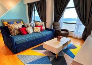 a living room with a blue couch and a table at Comfy Imperium Residence Kuantan Studio Seaview in Kuantan