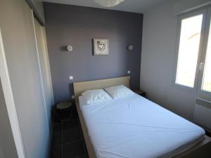 a bedroom with a white bed with a window at Appartement Banyuls-sur-Mer, 3 pièces, 4 personnes - FR-1-309-4 in Banyuls-sur-Mer