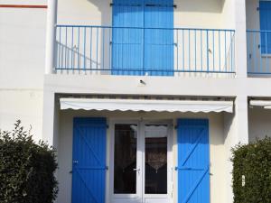 een huis met blauwe deuren en een balkon bij Appartement La Tranche-sur-Mer, 2 pièces, 4 personnes - FR-1-22-229 in La Tranche-sur-Mer