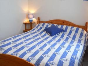 een blauw en wit bed in een slaapkamer met een lamp bij Appartement La Tranche-sur-Mer, 2 pièces, 4 personnes - FR-1-22-229 in La Tranche-sur-Mer