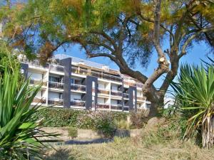an apartment building with a tree in front of it at Appartement T3 avec Terrasse à 30m des Commerces et Plage à Ploemeur - FR-1-349-72 in Ploemeur