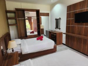 a hotel room with a bed and a television at Ramayana Hotel in Sanur