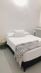 Una cama blanca con una manta en una habitación en Aloja-T en Apartamento amoblado 4 en Ciudad Bolivar en Ciudad Bolívar