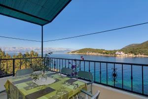a balcony with a table and a view of the water at Apartment and Rooms Nikola in Zastražišće
