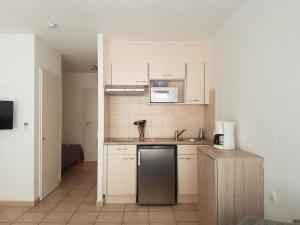 uma cozinha com armários brancos e um frigorífico de aço inoxidável em Studio Saint-Raphaël, 1 pièce, 3 personnes - FR-1-466A-18 em Saint-Raphaël