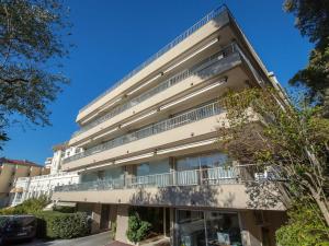 un edificio de apartamentos con balcones y árboles en Studio Saint-Raphaël, 1 pièce, 3 personnes - FR-1-466A-32, en Saint-Raphaël