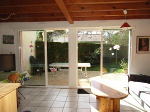 a room with a sliding glass door with a table at Maison T3 à Biscarrosse Lac - 4/6 pers - Jardin, terrasse, proche lac et pistes cyclables - FR-1-521-116 in Biscarrosse