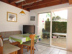 a living room with a table and a sliding glass door at Maison T3 à Biscarrosse Lac - 4/6 pers - Jardin, terrasse, proche lac et pistes cyclables - FR-1-521-116 in Biscarrosse