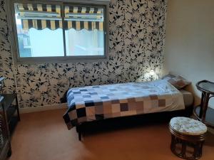 een kleine slaapkamer met een bed en een raam bij Appartement Biarritz, 2 pièces, 4 personnes - FR-1-239-581 in Biarritz