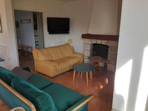 ein Wohnzimmer mit einem Sofa und einem Kamin in der Unterkunft Maison Hendaye, 7 pièces, 12 personnes - FR-1-239-492 in Hendaye