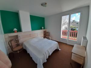 1 dormitorio con cama blanca y ventana grande en Maison Hendaye, 7 pièces, 12 personnes - FR-1-239-492, en Hendaya