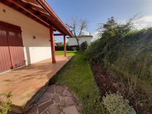 a porch of a house with a wooden walkway at Maison 3* à Hendaye, proche plage et commerces, jardin privé, parfait pour familles et amis - FR-1-239-492 in Hendaye
