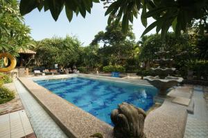 uma piscina num resort com uma fonte em Ramayana Hotel em Sanur