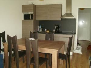 a kitchen with a wooden dining table and chairs at Appartement T3 avec piscine, sauna en front de mer à Biscarrosse Plage - FR-1-521-1 in Biscarrosse-Plage