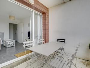 ein Esszimmer mit einem weißen Tisch und Stühlen in der Unterkunft Appartement T3 moderne à Biscarrosse Plage, proche océan, terrasse et parking - FR-1-521-9 in Biscarrosse-Plage